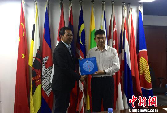 中國—東盟博覽會秘書處副秘書長黃平西（右）與柬埔寨新聞部新聞與傳播總司副總司長春占皮侖（左）互贈禮物。