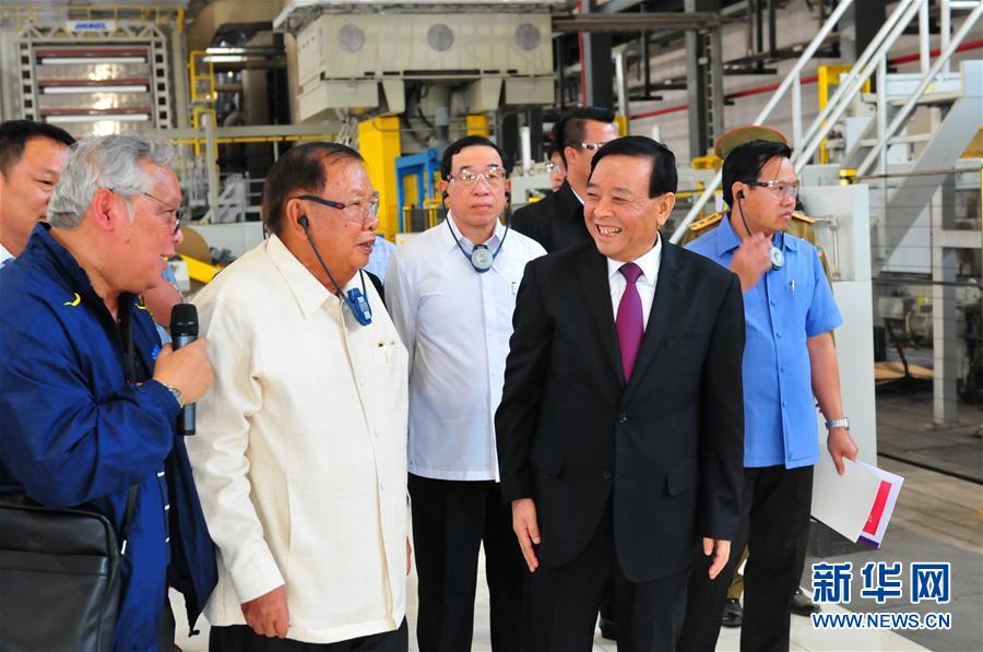 3月10日，在老撾沙灣拿吉省車邦縣，老撾人民革命黨中央總書記、國家主席本揚（左二）在山東太陽紙業(yè)股份有限公司董事長李洪信（右二）的陪同下視察公司。 新華社記者章建華攝